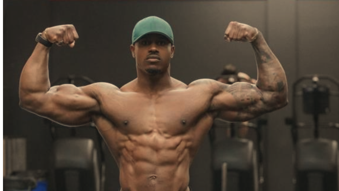 Simeon Panda chest exercise swaps: muscular man flexing in gym.