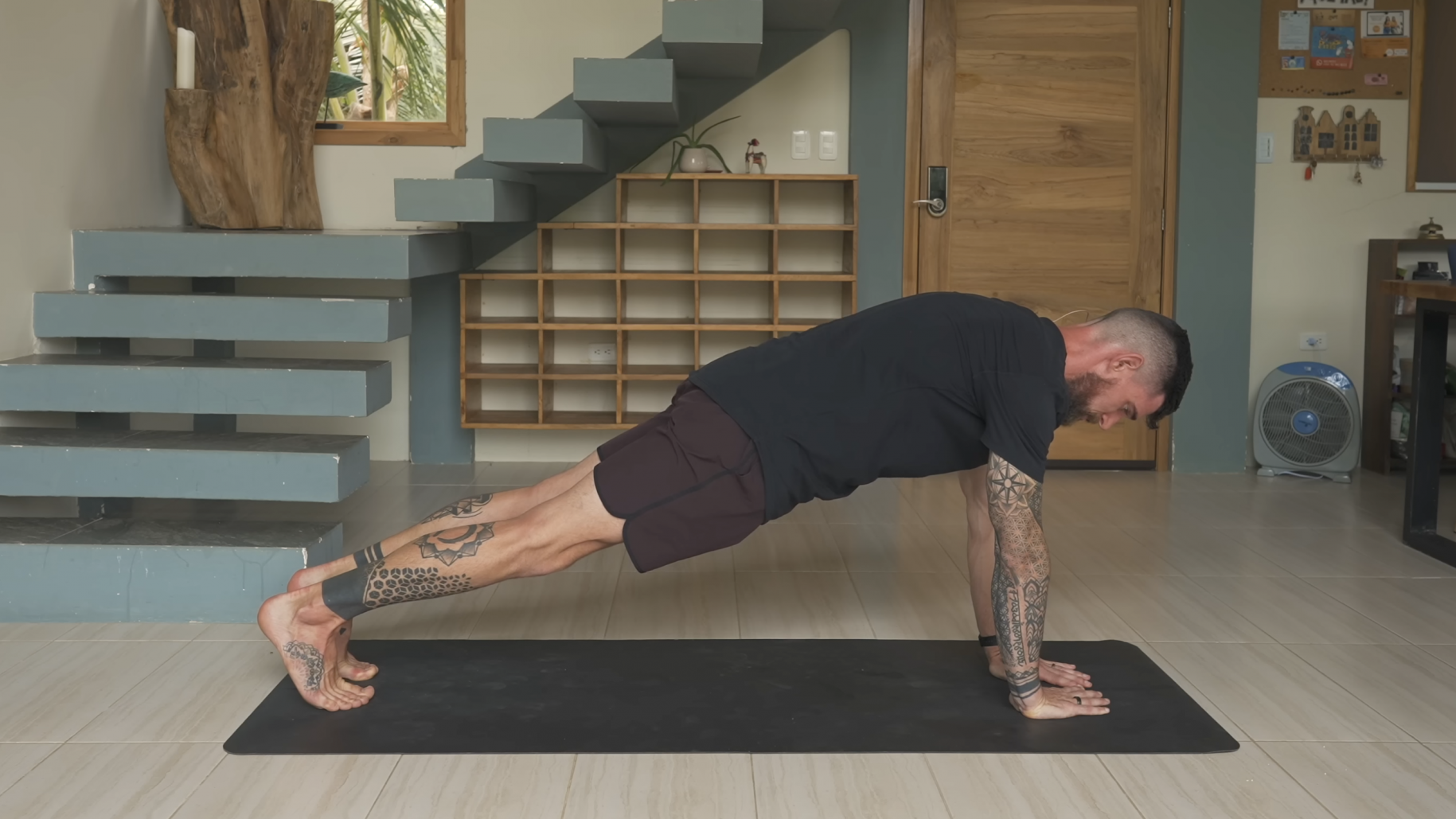 Young woman performing squats for total body toning workout, bright bedroom setting.