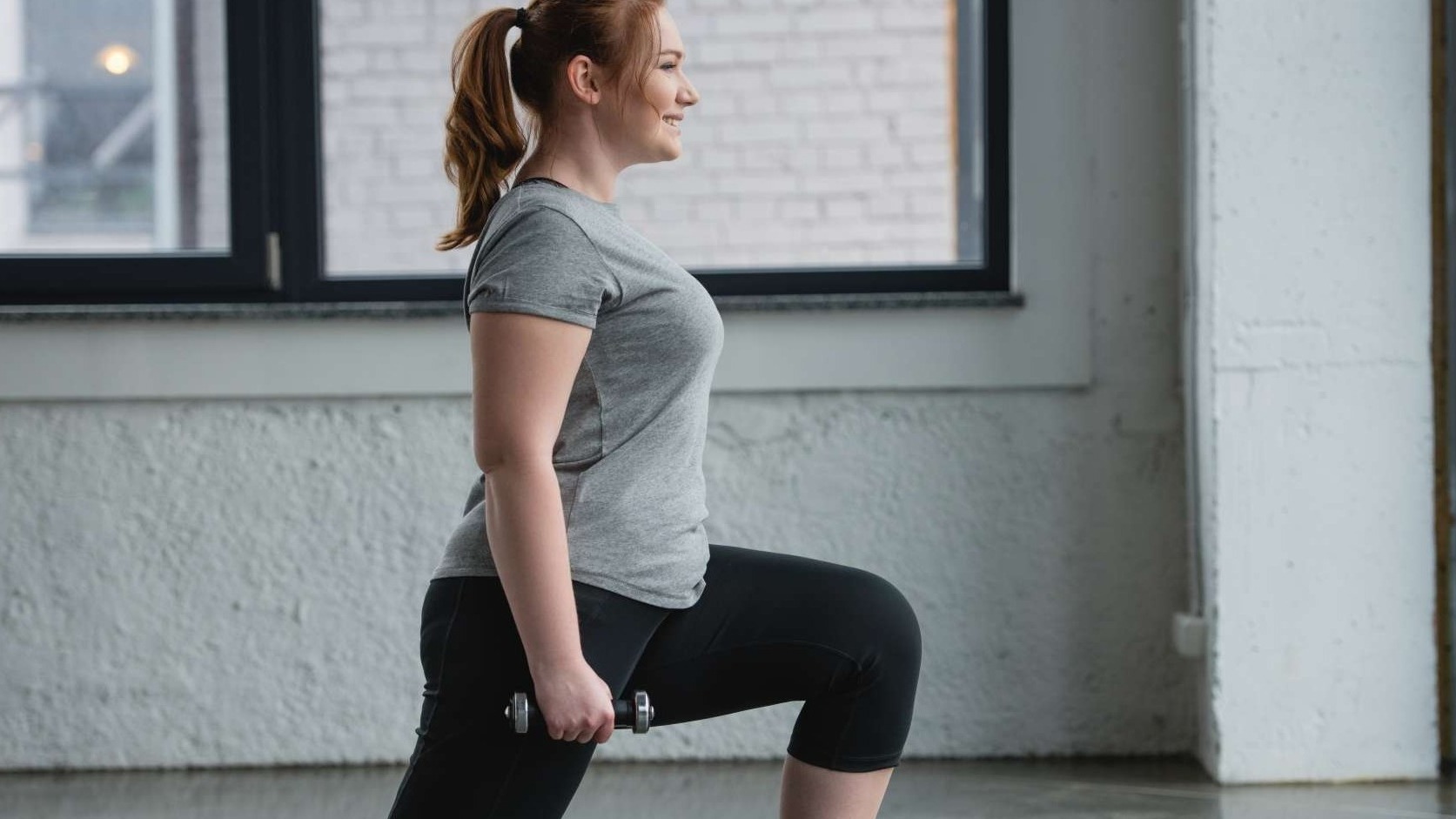 Energetic person mid-dumbbell workouts, showcasing strength and determination.