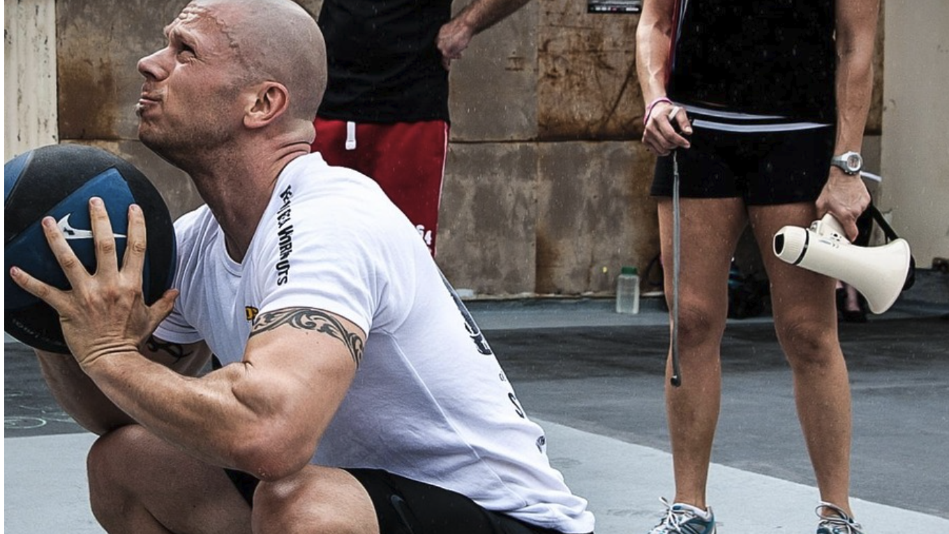 Woman in 40s demonstrating strength training after 40 in a bright gym setting.