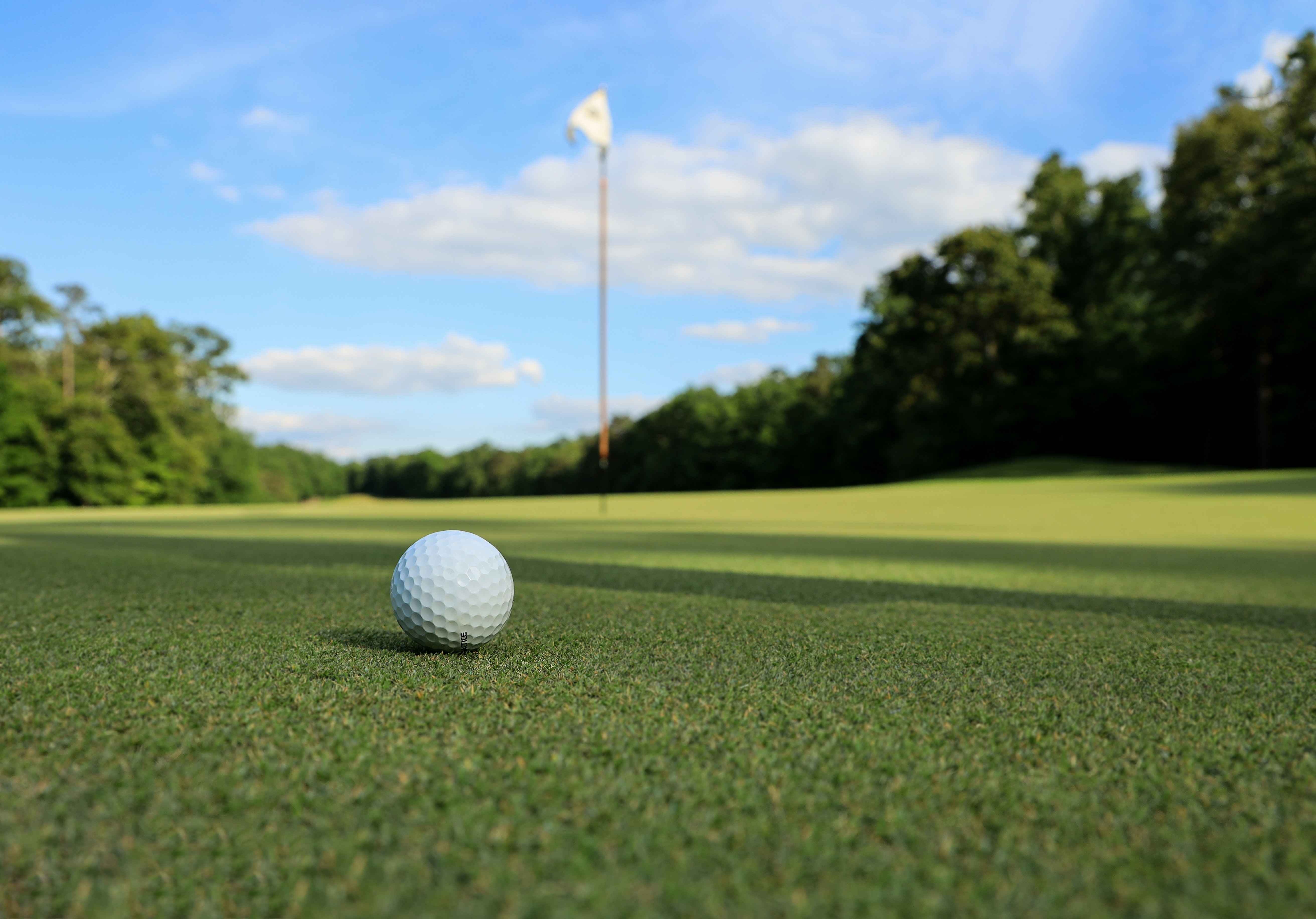 Close up on golf ball near hole with flag