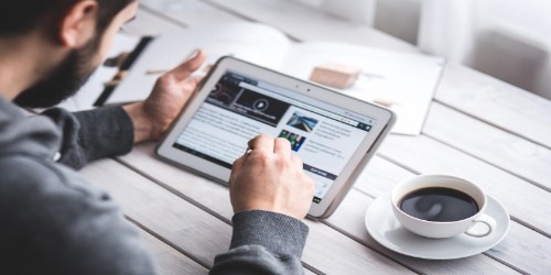 Man reading blog on his tablet