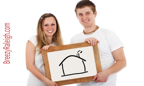 young couple holding house drawing picture