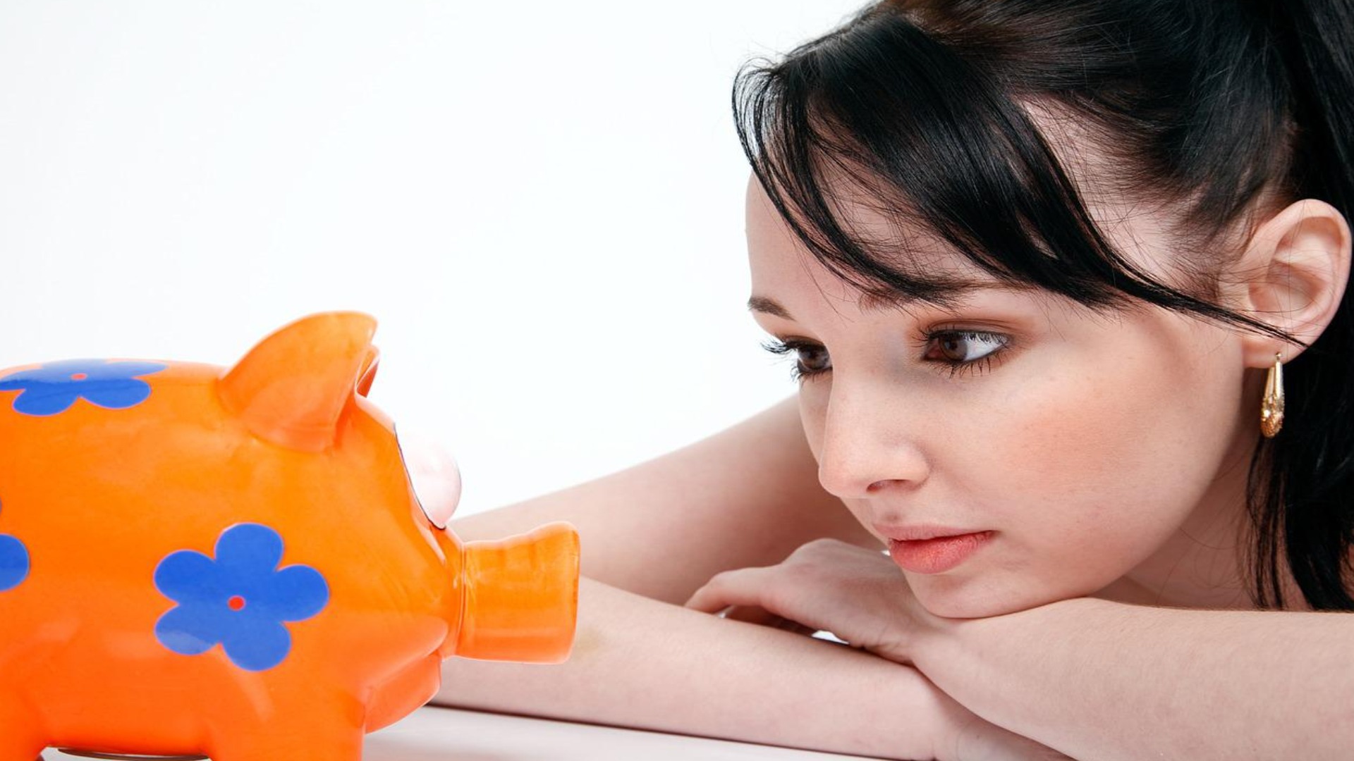 female staring at piggy bank