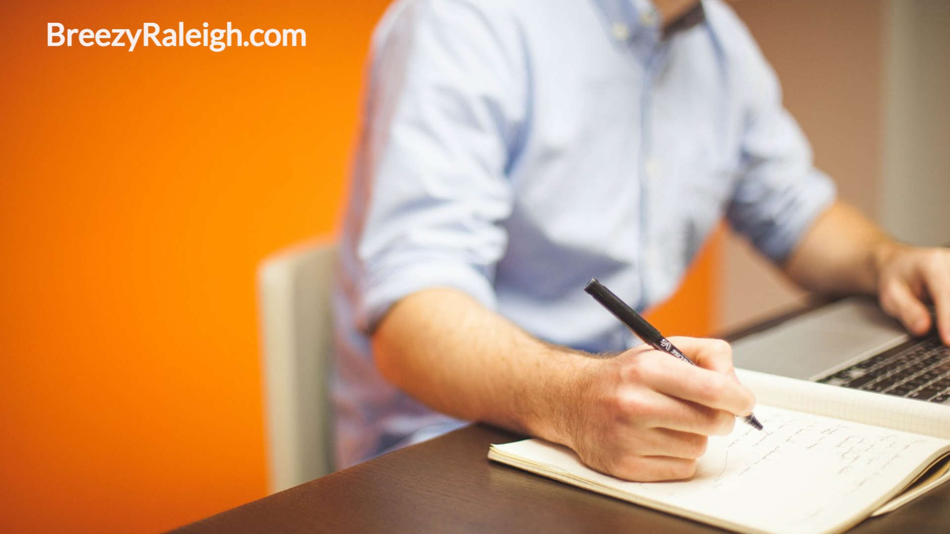 man at his desk writing notes