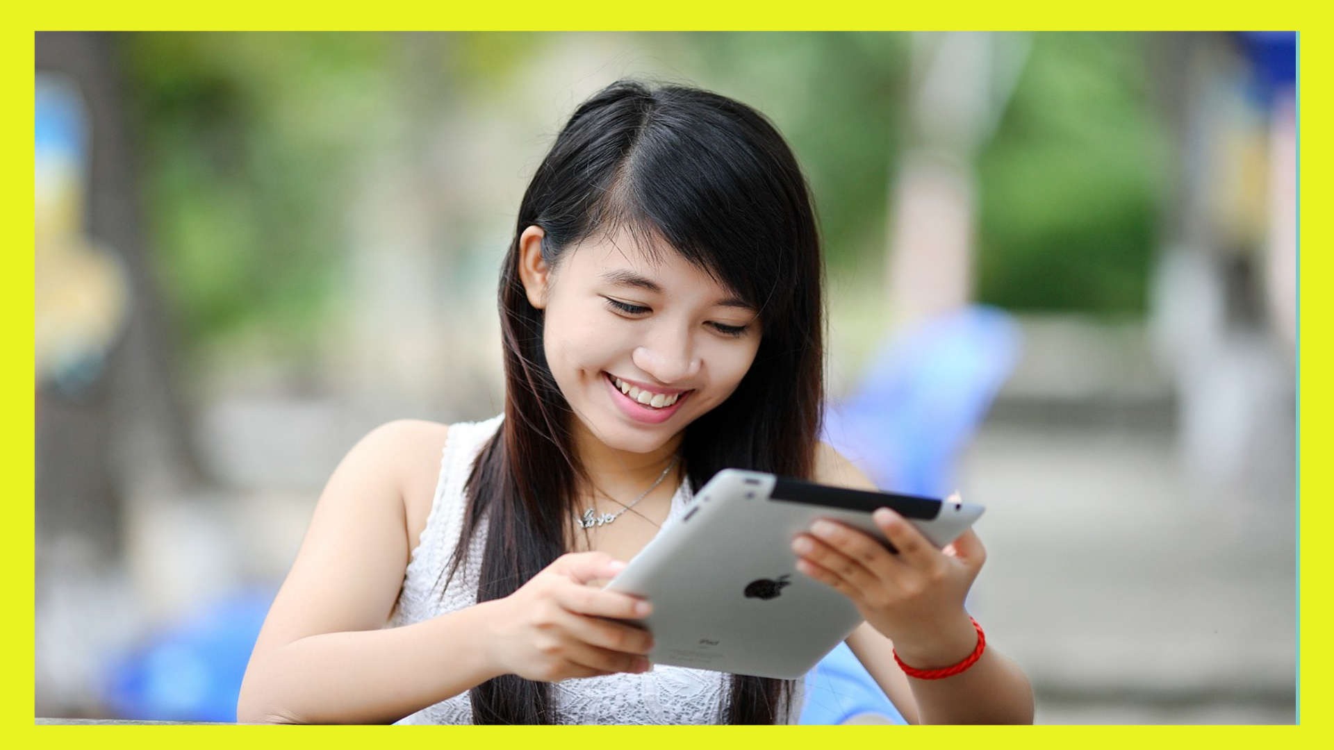 smiling woman looking at tablet