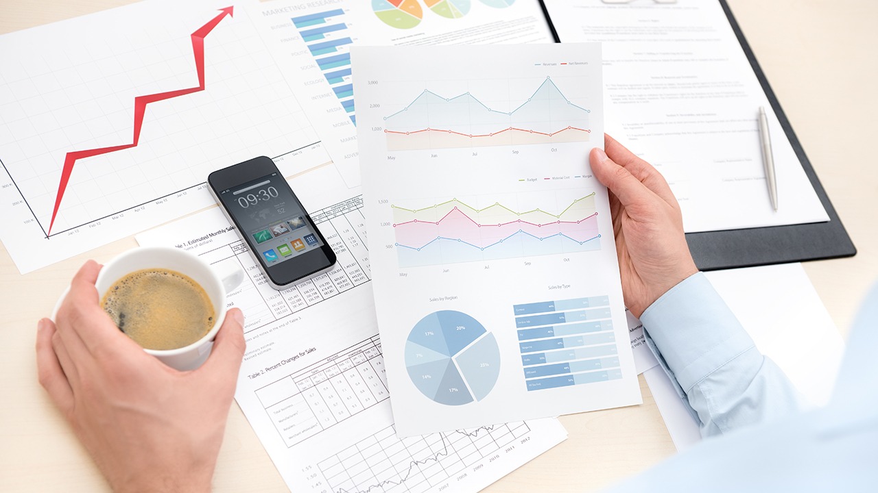 professional with coffee looking at charts