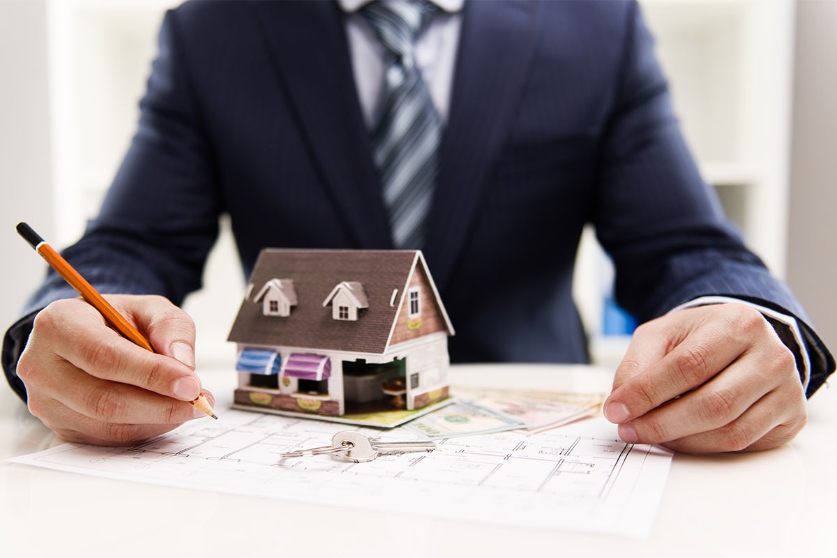 Professional man with pencil and model house