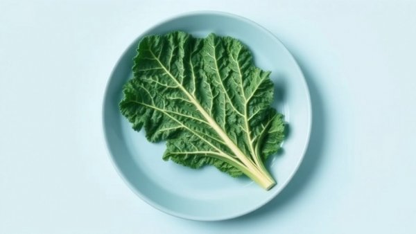 Leaf of kale on blue plate with light cyan background.