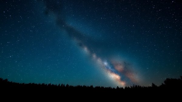 Expansive starry sky with Milky Way over Denver horizon, capturing serene night.