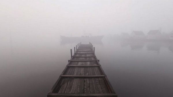 Foggy river with old pier and distant houses; Westham Island Bridge closure.