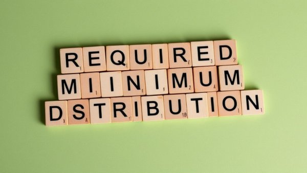 Wooden blocks spelling 'REQUIRED MINIMUM DISTRIBUTIONS RMD' on green.