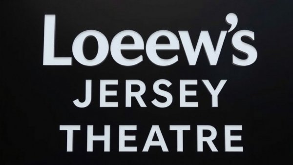 Loew's Jersey Theatre reopening sign in bold white letters on black.
