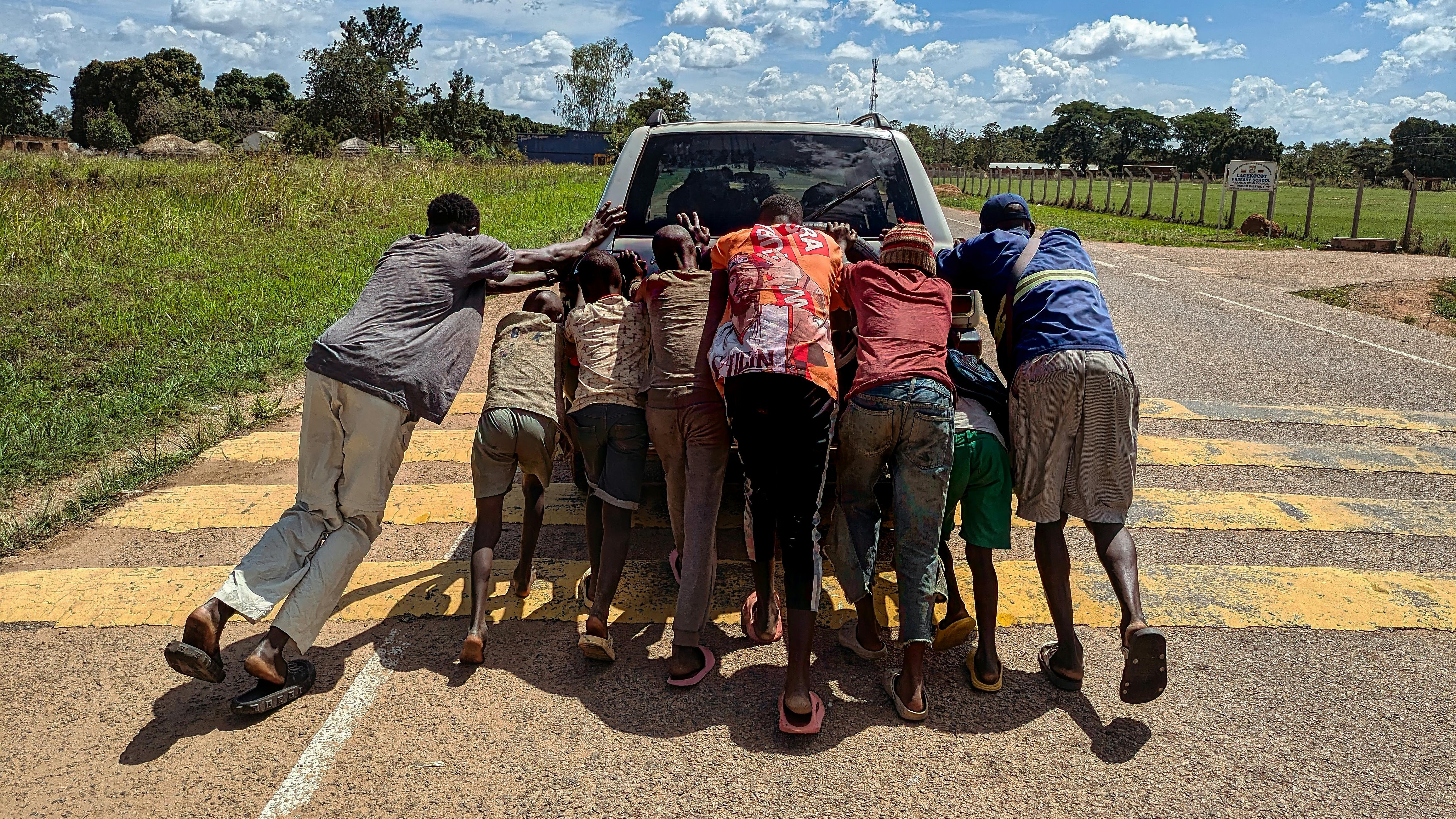 Uplifting Ugandan family and young professionals exercising together in a small living room, showing movement as medicine and joyful health habits.