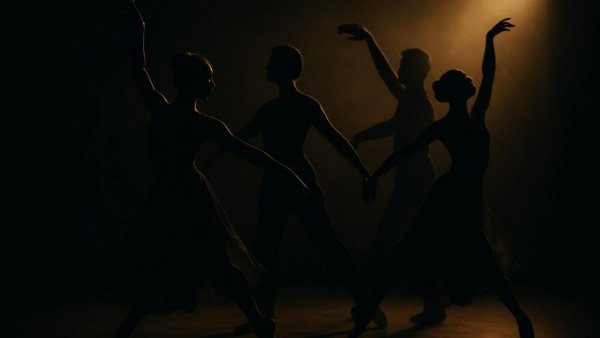 Dancers silhouetted in dim light during Beegie Adair's sophisticated jazz performance.