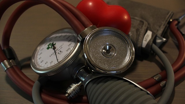 African doctor examining blood pressure of young adult for hypertension checks.