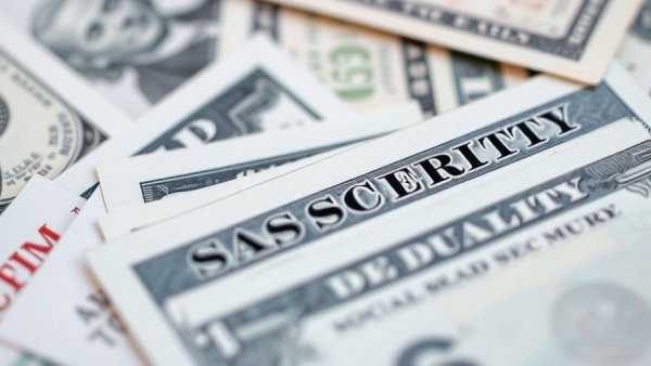 Social security cards stacked on US currency to maximize benefits Muskegon.