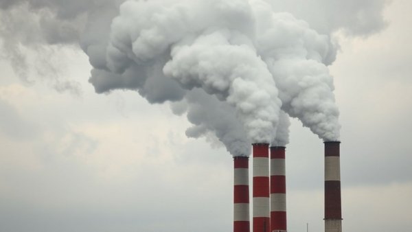 Industrial chimneys emitting smoke highlighting air pollution's impact.