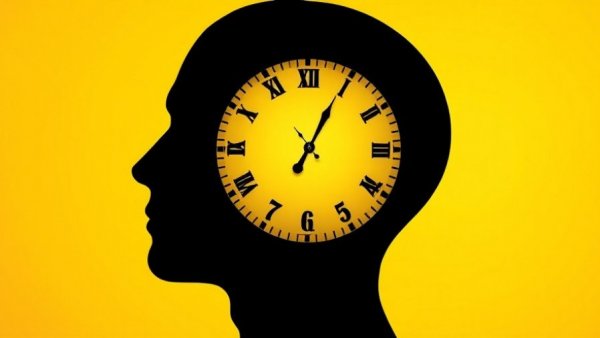 Silhouette of head as clock on yellow, circadian rhythms concept.