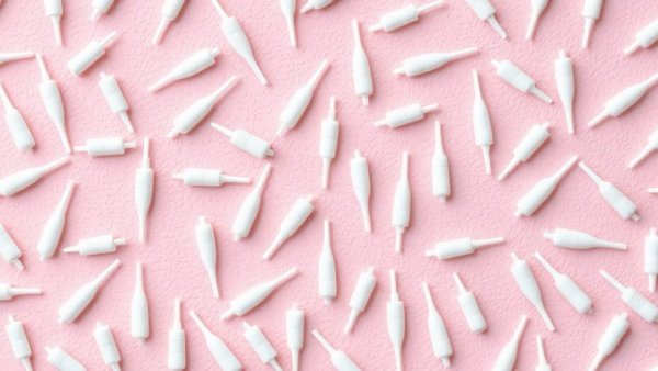 Pattern of IUDs on pink background, related to signs of pregnancy with an IUD.