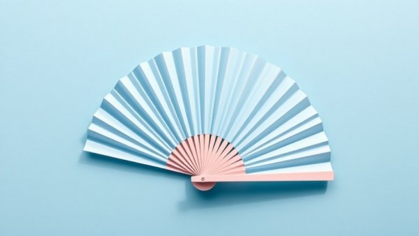 Decorative hand fan on blue surface, symbolizing cooling.