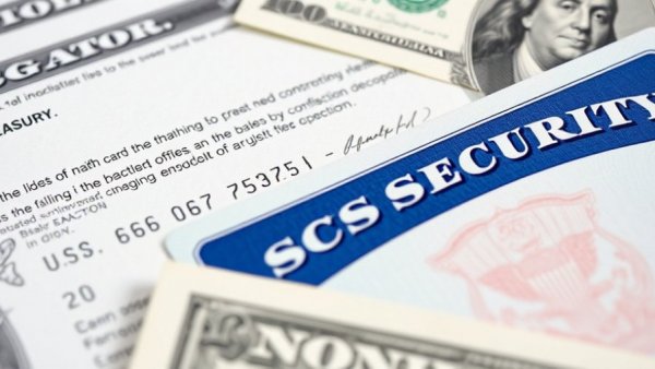 November Social Security Payment: Card and check with cash backdrop.