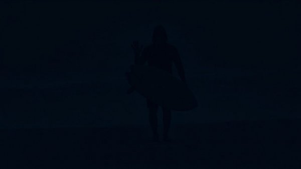 Get Rich Quick Business Idea for Surfers: Surfer illuminated at night, mysterious atmosphere.