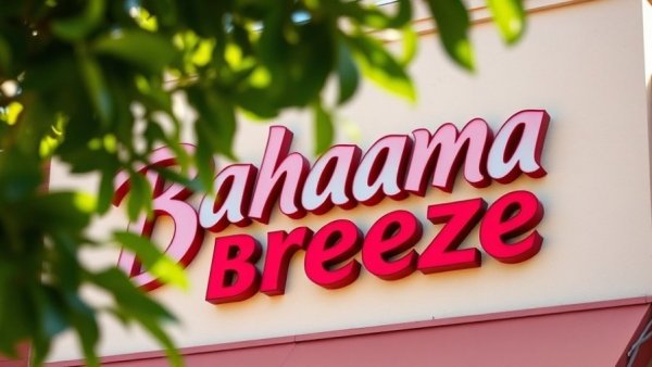 Bahama Breeze sign on beige wall, partial view with leaves.
