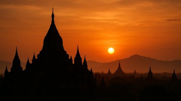 Ancient Myanmar temple at sunset, peaceful silhouette view