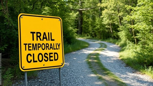 Northern Rail Trail closed sign amid property dispute.