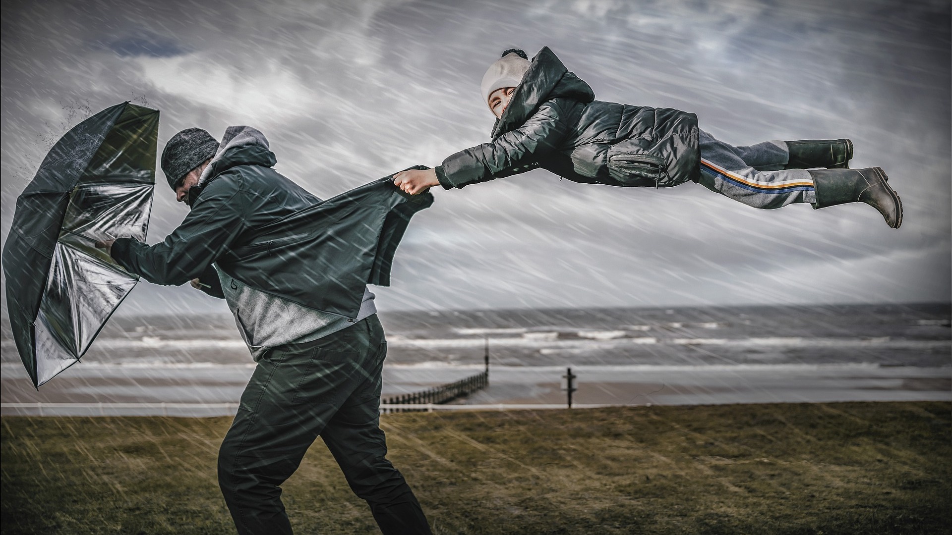 Image shows father and son in the kind of windy weather unsuitable for bouncy castle hire weather