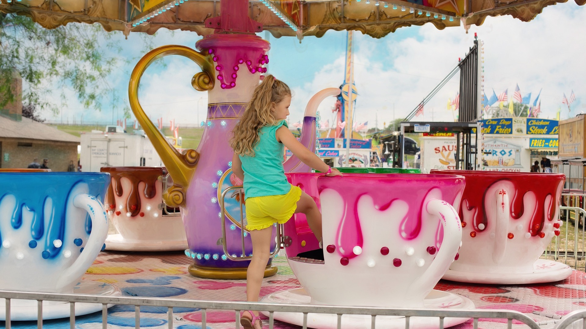 Child enjoying summer fair hire with a tea cup ride from Monster Inflatables