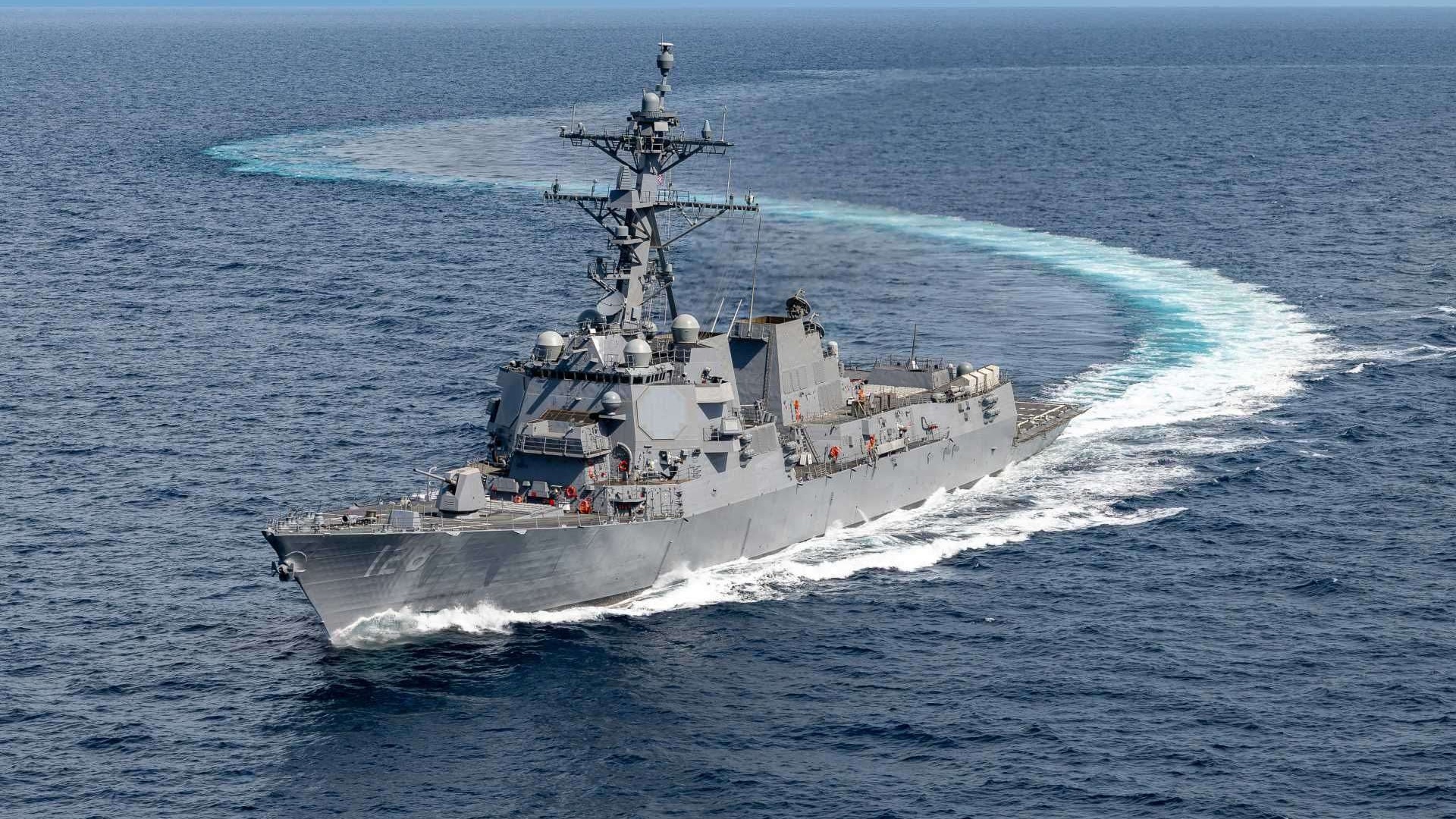 US Navy personnel with hardhats signing documents.