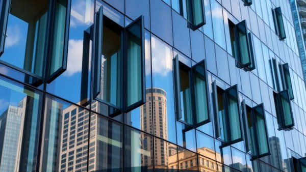 Modern building with reflective glass facades and open windows demonstrating aerogel insulation for homes.