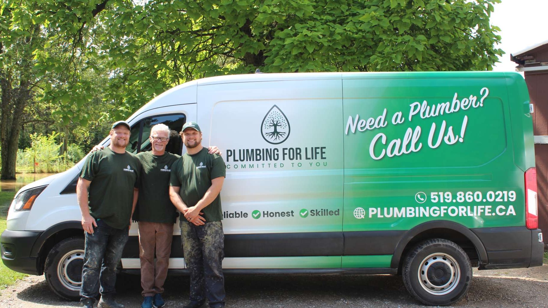Plumber examining leaky pipes under a bathroom sink for repairs.