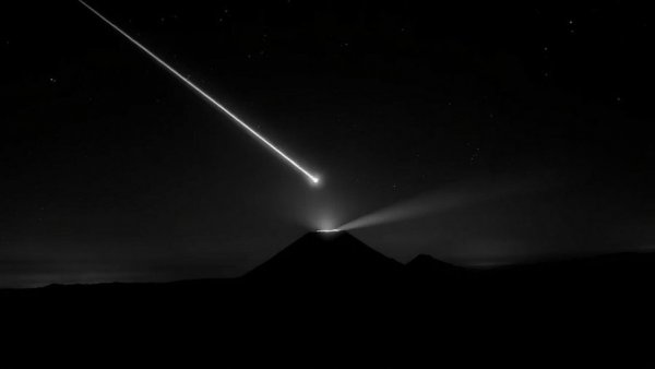 Meteor observed over Mayon Volcano emitting bright light at night.