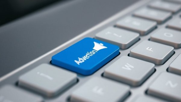 Close-up of blue advertising key on keyboard symbolizing free advertising ideas for small businesses.