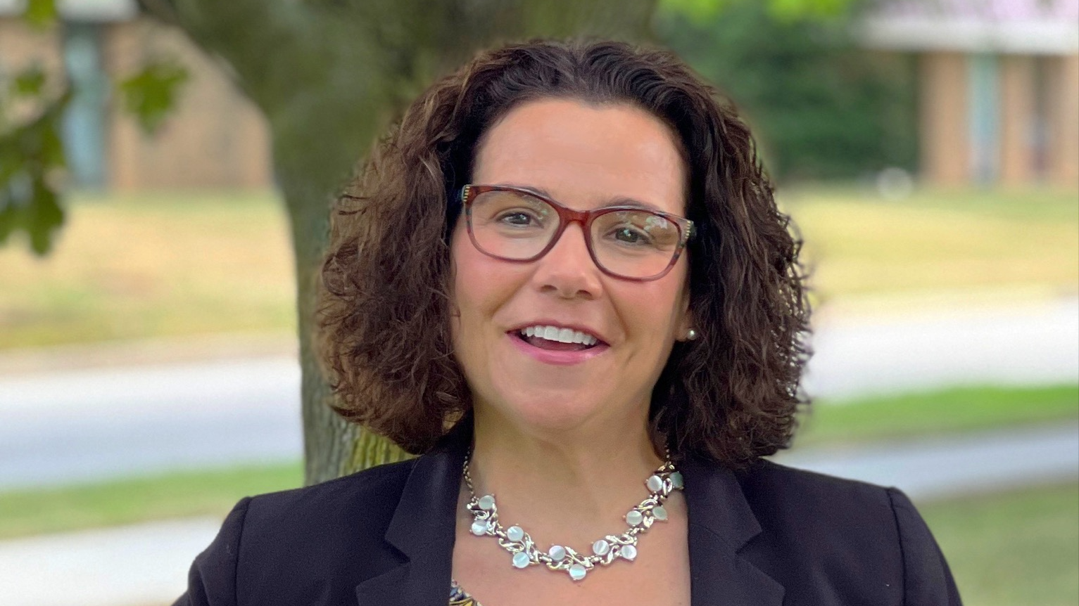 CertaPro Brand Strategy: Confident woman in business attire smiling outdoors.