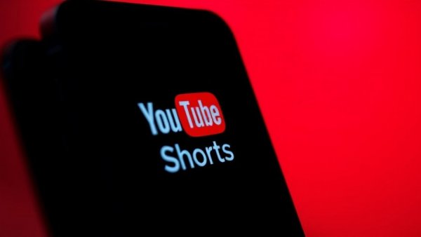 YouTube AI likeness in vibrant smartphone display with Shorts logo.