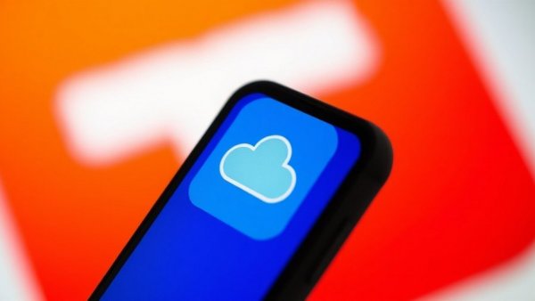 Smartphone showing Sora app with OpenAI logo in background.