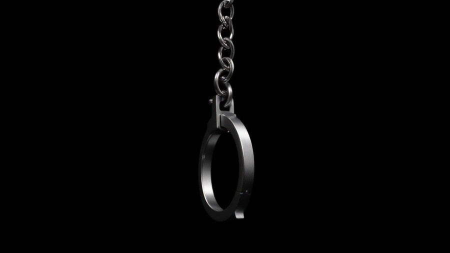 Suspended handcuff in darkness symbolizing arrest