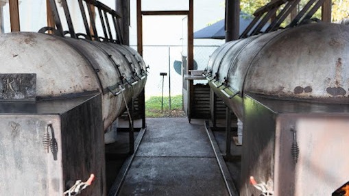 Fort Worth barbecue scene with two chefs grilling outdoors.