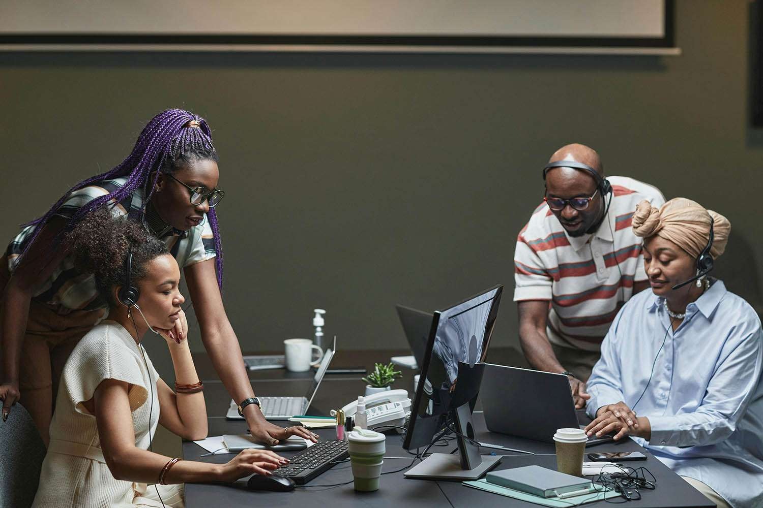 Dynamic social media marketing, strategically thinking, discussing plans, photorealistic, modern office with digital screens, highly detailed, interaction with tech gadgets, professional lighting, medium telephoto lens.