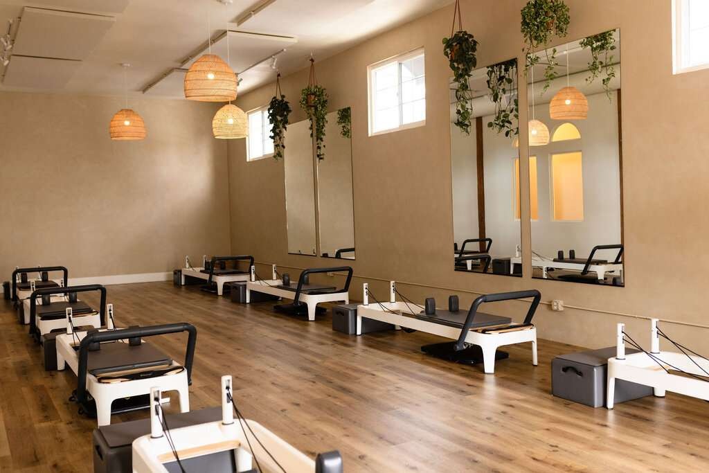 Pilates studio with reformers in use, reflecting guided movement and structure.