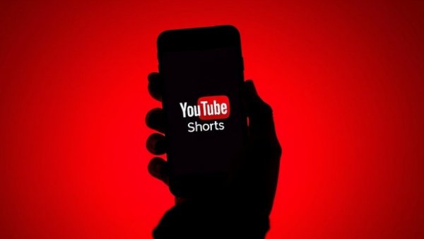 YouTube Shorts logo on smartphone with red background