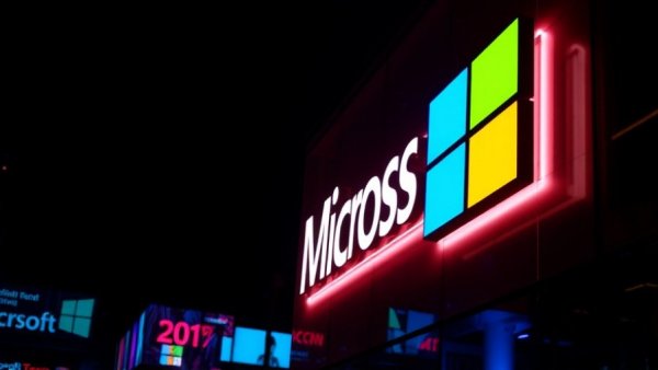 Illuminated Microsoft sign at night with vibrant lights.