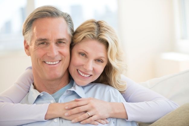 Middle age couple smiling after dental implants