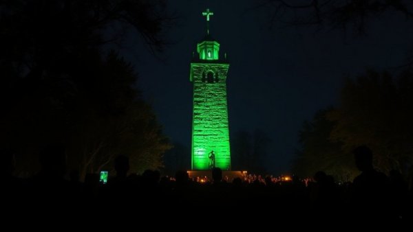 MSU shooting anniversary vigil with green-lit tower at night.