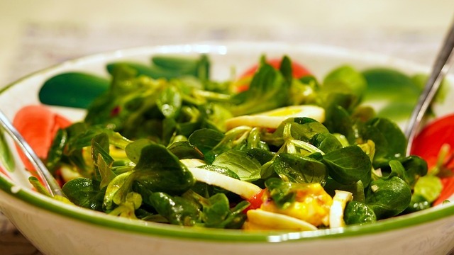 Shaved Brussels sprouts salad with cranberries and pecans in a wooden bowl.