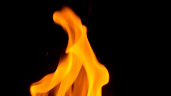 Vivid flame flickering upwards on a dark backdrop